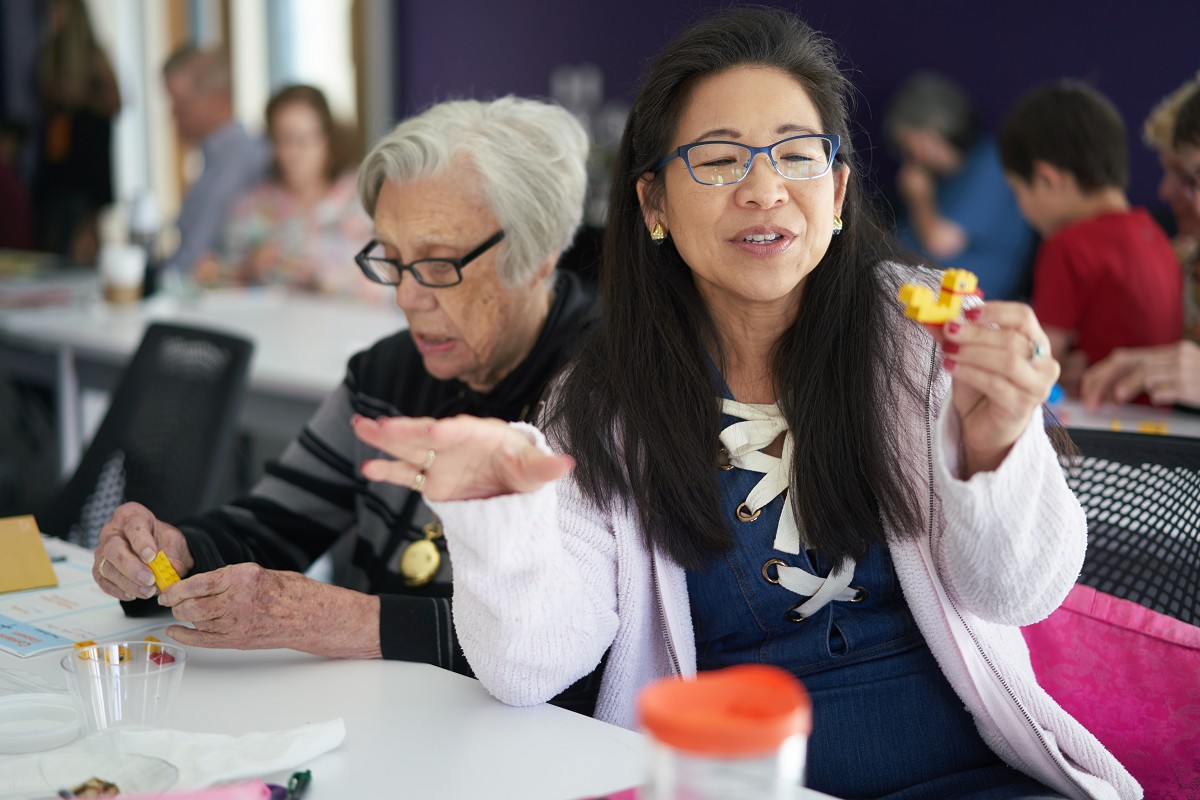 Woman excitedly shares her LEGO duck during facilitator training event